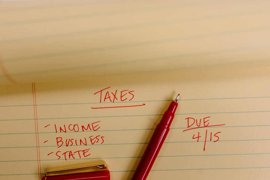 Close-up of tax-related notes on a yellow legal pad with red pen, highlighting important due dates.